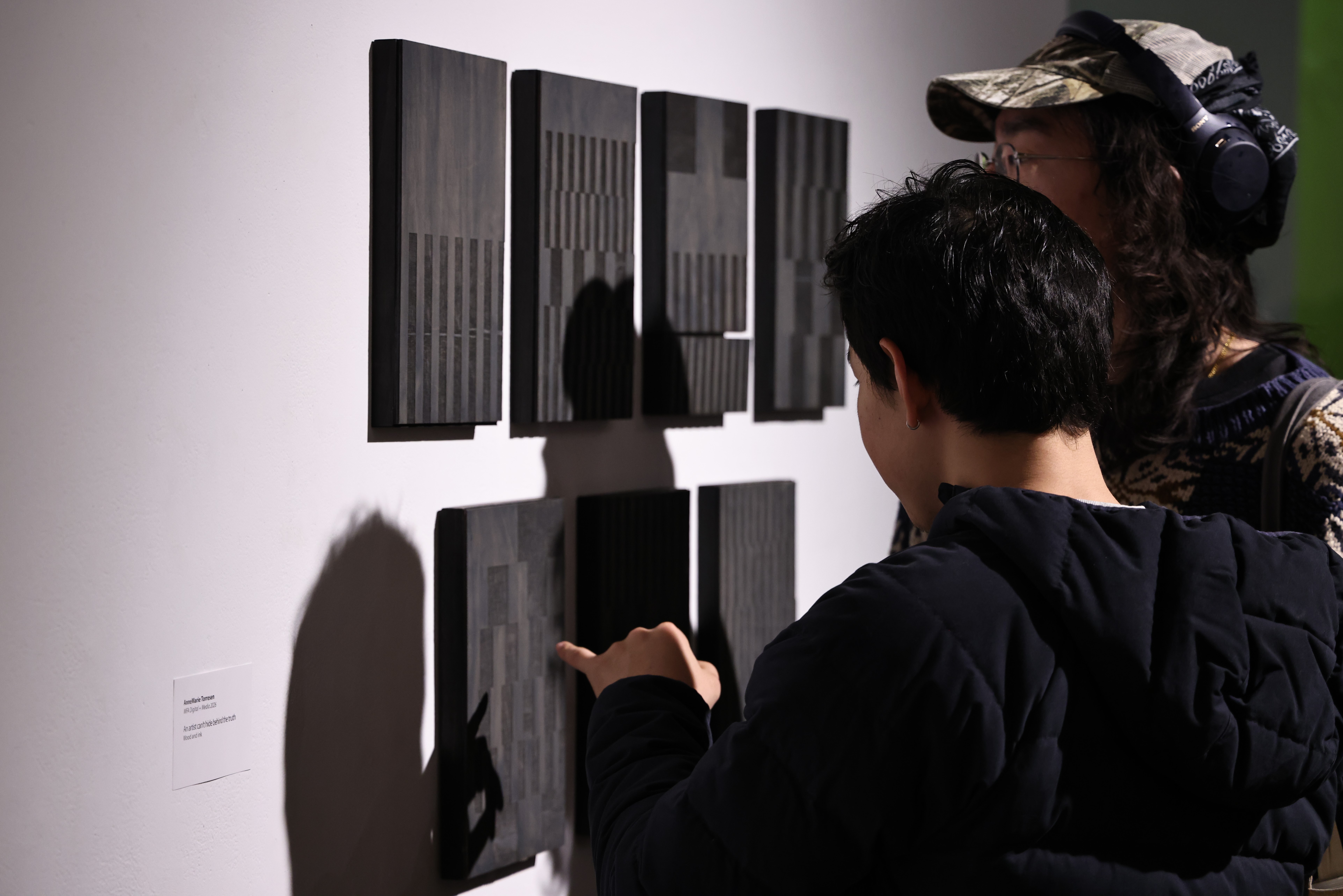 People look closely and point at a work of art containing a hidden message