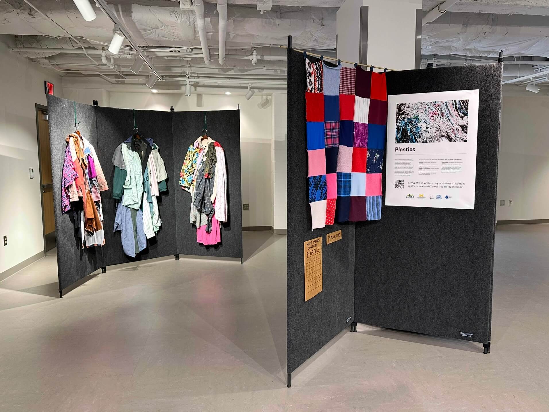 An art gallery showing textiles made from fabric scraps and informational posters about the environmental costs of fast fashion