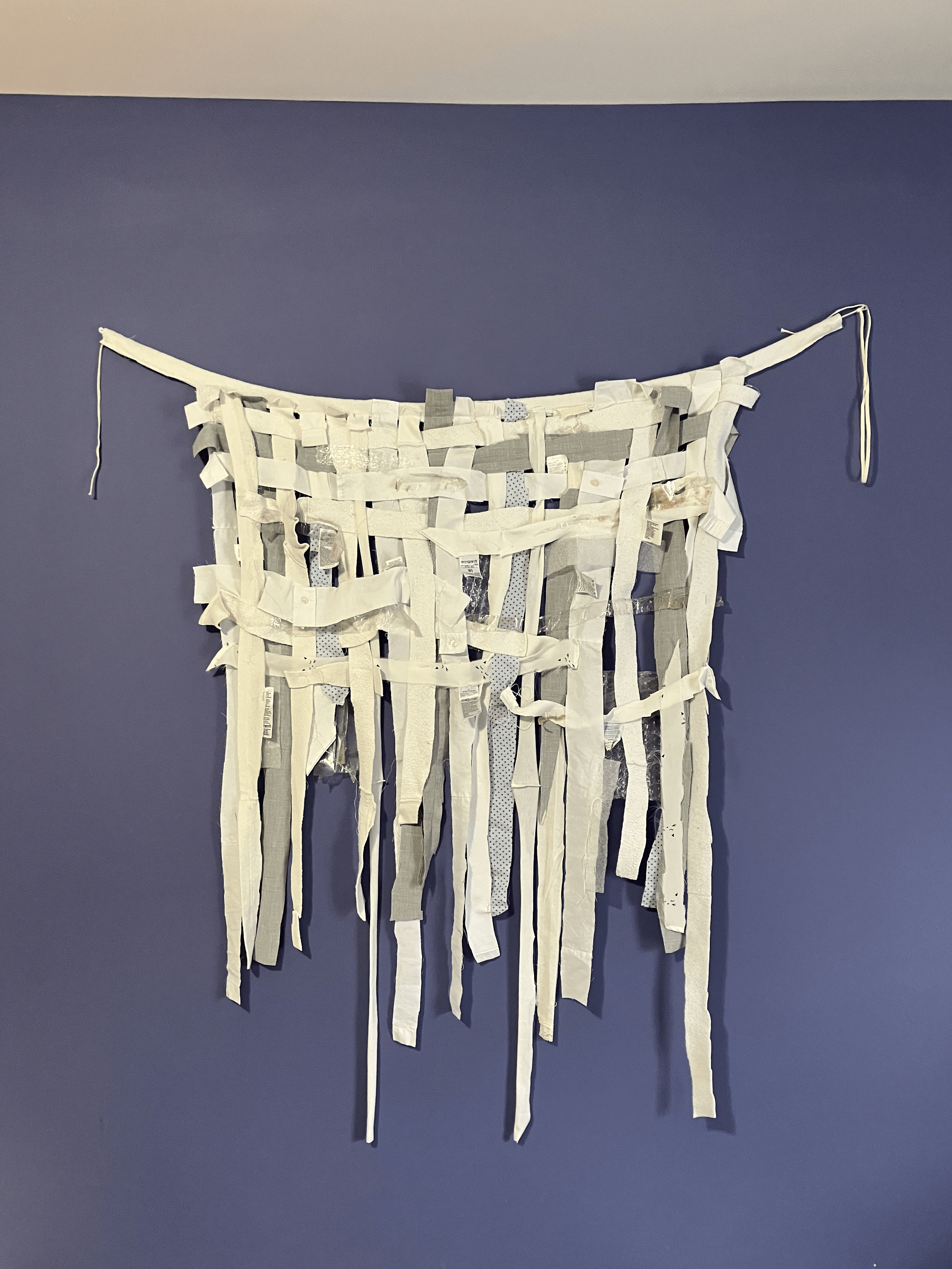 A weaving of packaging materials and scraps of trash-bound clothes